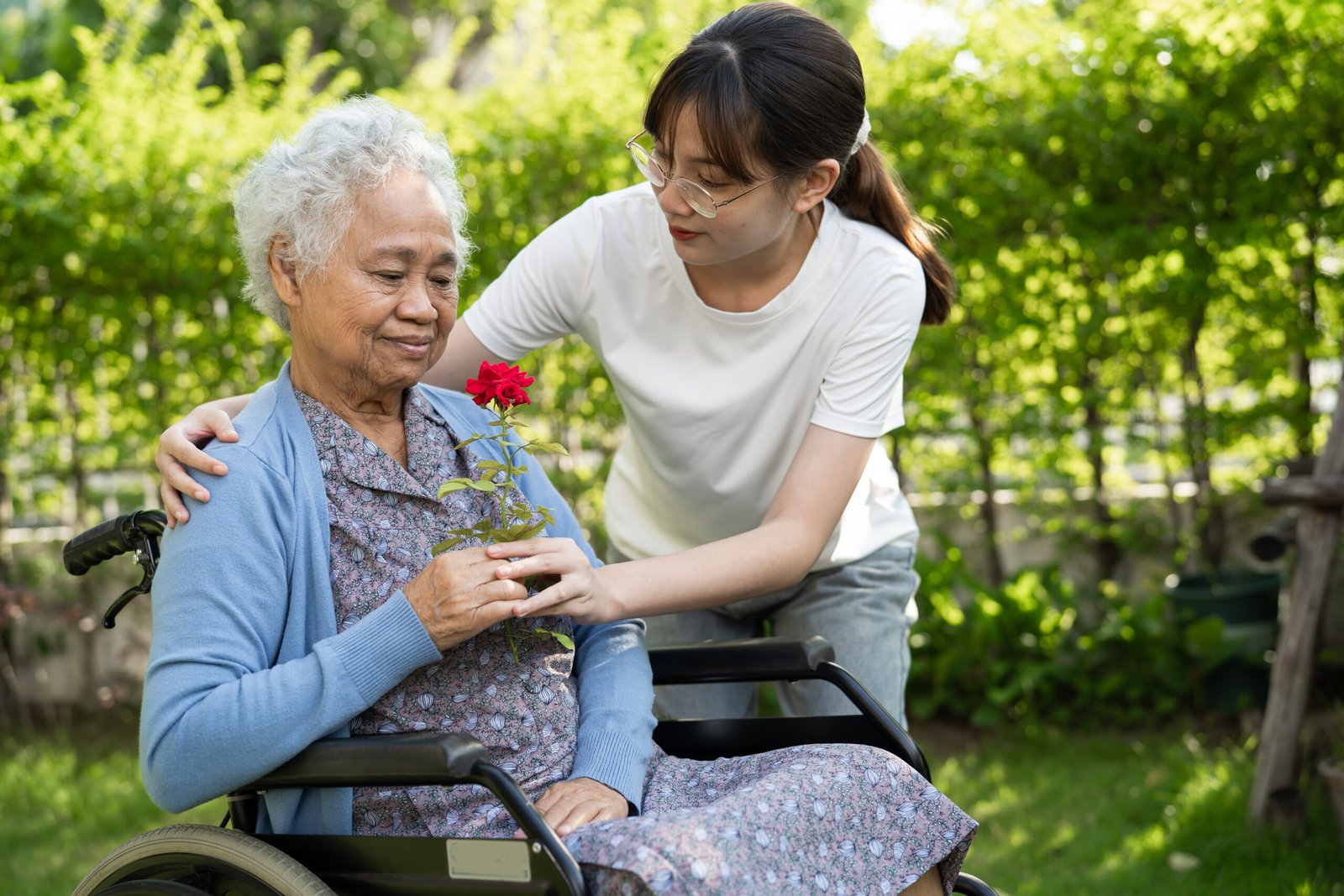 Caregiver supporting a senior client outdoors, representing services eligible for AHS Home Care and Alberta Blue Cross invoicing.