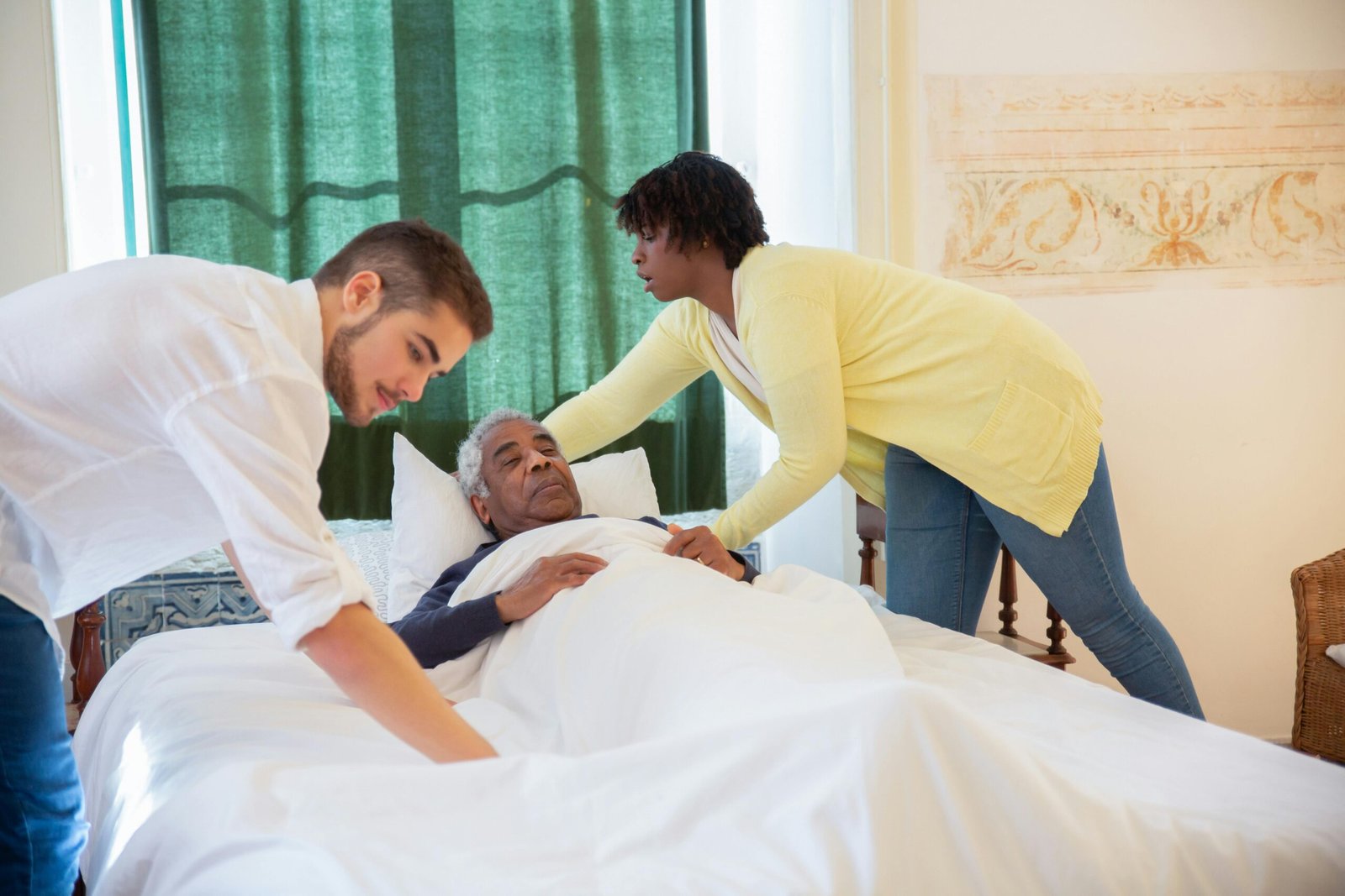 Caregiver assisting a senior man in bed, providing essential personal care and daily living support for safety.