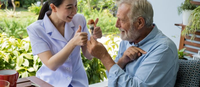 Caregiver and happy senior giving a thumbs up, representing premium concierge home care and lifestyle management.